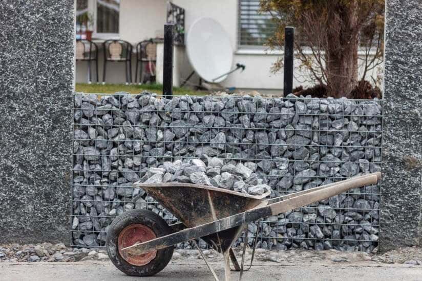 Schubkarre vor Gabionen