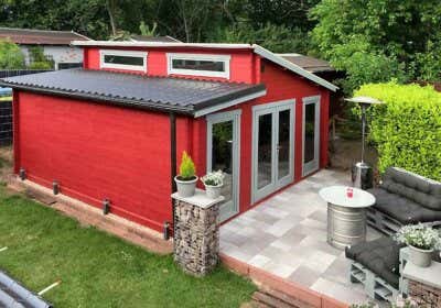 Mut zur Farbe: Rotes Gartenhaus mit Innensauna