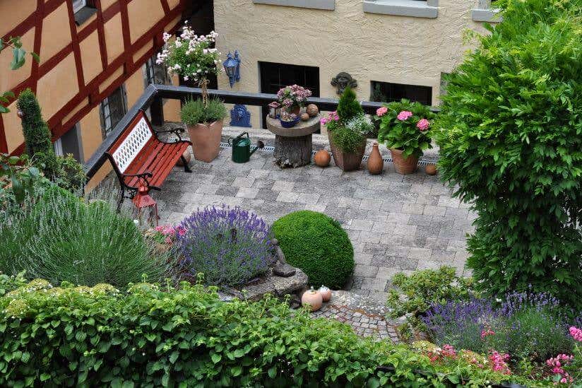 Dachgarten mit Pflanzen und Ausblick auf umliegende Gebäude